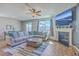 Comfortable living room featuring a cozy fireplace, ceiling fan, and plenty of natural light at 215 Shortmarsh St, Summerville, SC 29486