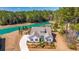 Aerial view of the property featuring a home, long driveway, landscaping, and vibrant lake at 225 Camber Rd, Huger, SC 29450