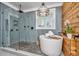 A luxury bathroom with a soaking tub, glass-enclosed shower, and wood paneled accent wall at 225 Camber Rd, Huger, SC 29450