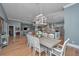 Open dining room with a rustic wood table set beneath a unique, modern chandelier and open to the living and kitchen areas at 225 Camber Rd, Huger, SC 29450