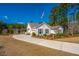 Inviting home featuring classic design, a long driveway, manicured landscaping, and an American flag at 225 Camber Rd, Huger, SC 29450