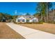 Charming single-Gathering home with a long driveway and an American flag in a lush, treed lawn at 225 Camber Rd, Huger, SC 29450