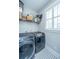 Well-equipped laundry room featuring modern washer and dryer, ample shelving, and patterned floor at 225 Camber Rd, Huger, SC 29450