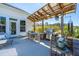 Covered outdoor patio area with dining set, grill, and views of the backyard and lake at 225 Camber Rd, Huger, SC 29450