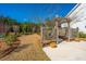 Cozy lattice-covered patio with garden and lush backyard landscaping with mature trees at 225 Camber Rd, Huger, SC 29450