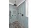 Close-up of the blue tiled shower with rainfall shower head and mosaic tiled floor at 225 Camber Rd, Huger, SC 29450
