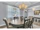 Bright dining room featuring a large window, chandelier, decorative table and wood chairs at 225 Waning Way, Charleston, SC 29492