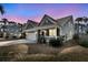Beautiful home features a covered front porch, two-car garage, and manicured lawn at twilight at 225 Waning Way, Charleston, SC 29492