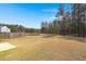 Large grassy backyard with a pond and trees, offering serene views at 229 Coral Sunset Way, Summerville, SC 29486