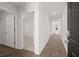 Bright hallway featuring wood-look floors and white doors, offering a welcoming and neutral space at 229 Coral Sunset Way, Summerville, SC 29486