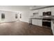 Bright kitchen features white cabinets, stainless steel appliances, and wood-look flooring open to living area at 229 Coral Sunset Way, Summerville, SC 29486