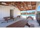 Covered patio area near the pool with tables and seating, perfect for relaxation and gatherings at 229 Coral Sunset Way, Summerville, SC 29486