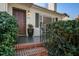 Close-up of the inviting front porch with a brick steps, lush greenery, and an elegant front door at 229 Gordon St, Charleston, SC 29403