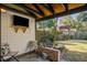 Outdoor patio area with TV, seating, and view of landscaped backyard with playhouse at 229 Gordon St, Charleston, SC 29403