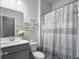 Bright bathroom boasts a sleek vanity, toilet, and a shower with striped curtain and decorative wall hangings at 265 Celestial Blvd, Summerville, SC 29486