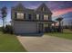Charming two-story home with a well-manicured lawn, a two-car garage and a beautiful dusk sky at 265 Celestial Blvd, Summerville, SC 29486