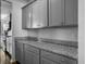 Close-up of gray kitchen cabinets with granite countertops, silver hardware and stainless steel appliances at 265 Celestial Blvd, Summerville, SC 29486
