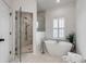 Bright bathroom with modern tub, glass-enclosed shower, and tiled floors at 3019 Viscount St, Charleston, SC 29424