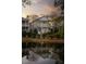 Elegant two-story house reflected in a serene pond with mature trees, surrounded by lush landscaping at sunset at 3019 Viscount St, Charleston, SC 29424