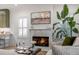 Cozy living room features a marble fireplace, large plant and white shutters at 3019 Viscount St, Charleston, SC 29424