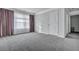Neutral bedroom featuring gray carpet, crown molding, large windows with curtains, and a closet at 302 Willow Pointe Cir, Summerville, SC 29486