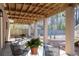 Covered patio with wood ceiling and chairs, offering a shaded outdoor living space with backyard access at 3021 Rushland Mews, Johns Island, SC 29455
