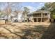 Beautiful backyard featuring a spacious lawn, mature trees, and a two-story home with a large deck, perfect for outdoor living at 3021 Rushland Mews, Johns Island, SC 29455