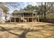 Expansive backyard view showcasing the home's deck, lower level patio, and ample green space at 3021 Rushland Mews, Johns Island, SC 29455