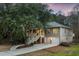 Charming two-story home featuring a welcoming staircase, a two-car garage, and manicured landscaping at dusk at 3021 Rushland Mews, Johns Island, SC 29455