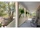 Covered front porch with ferns, comfortable seating, railing, and views of the surrounding greenery at 3021 Rushland Mews, Johns Island, SC 29455