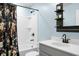 Modern bathroom with white vanity, black fixtures, and a shower/tub combo with a colorful curtain at 305 Lanyard St, Johns Island, SC 29455