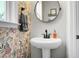 Charming powder room featuring a pedestal sink, round mirror, and floral wallpaper at 305 Lanyard St, Johns Island, SC 29455