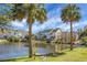 Picturesque pond surrounded by lush greenery, townhomes and clear blue sky at 305 Lanyard St, Johns Island, SC 29455