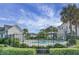 Community pool with palm trees, black metal fence, and well-manicured landscaping create a resort-style oasis at 305 Lanyard St, Johns Island, SC 29455