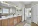Bathroom with double sinks, tile flooring, framed mirrors, and access to another room, creating a functional space at 314 Foxbank Plantation Blvd, Moncks Corner, SC 29461