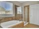 Bathroom featuring a soaking tub, a glass enclosed shower, and a large window letting in natural light at 314 Foxbank Plantation Blvd, Moncks Corner, SC 29461