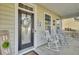 Welcoming front porch offers a seating area with rocking chairs and decorative wreath on front door at 314 Foxbank Plantation Blvd, Moncks Corner, SC 29461