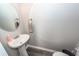 Neat powder room with pedestal sink, round mirror, and gray flooring at 317 Cantley Ct, Summerville, SC 29486