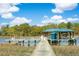 Scenic waterfront view of a private dock with blue-roofed gazebo and boat, nestled in a serene coastal landscape at 3398 Freeman Hill Rd, Johns Island, SC 29455