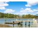 Waterfront view showcasing dockside amenities, including gazebos, a boat lift, and scenic surroundings at 3398 Freeman Hill Rd, Johns Island, SC 29455