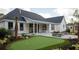 Outdoor living with a putting green and fire pit on the stone patio with a covered porch on this beautiful home at 3434 Kit Freeman Ln, Johns Island, SC 29455