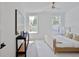 Bright, minimalist bedroom with wood floors, black console, white rug and a ceiling fan at 3434 Kit Freeman Ln, Johns Island, SC 29455