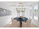 Dining room featuring a dark wood table and white chairs, lit by a modern chandelier, with natural light at 3434 Kit Freeman Ln, Johns Island, SC 29455