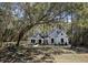 Exterior view of a charming two-story home nestled among mature trees at 3434 Kit Freeman Ln, Johns Island, SC 29455