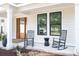 Inviting front porch with rocking chairs, plants, and view of the entry door at 3434 Kit Freeman Ln, Johns Island, SC 29455