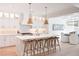 Bright kitchen with island seating and pendant lights, opens to a dining room with unique chandelier at 3434 Kit Freeman Ln, Johns Island, SC 29455