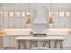 A gourmet kitchen featuring custom white cabinetry, quartz countertops, pendant lighting and seating at the island at 3434 Kit Freeman Ln, Johns Island, SC 29455