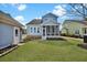 A spacious backyard showcases a well-maintained lawn, blue siding home, and a charming screened porch at 3676 Shutesbury St, Mount Pleasant, SC 29466
