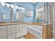 Bathroom with a double vanity, granite countertops, soaking tub, glass shower, and soft blue walls at 3676 Shutesbury St, Mount Pleasant, SC 29466