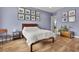 Bedroom with hardwood floors, an airy color scheme, a clean queen bed, and decorative wall art at 3676 Shutesbury St, Mount Pleasant, SC 29466